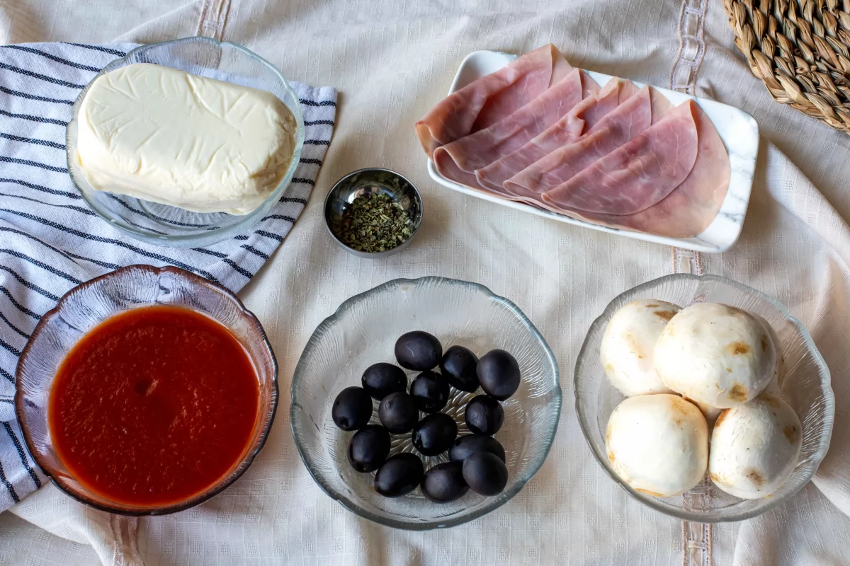 Ingredientes: mozzarella, tomate, jamón, aceitunas negras, champiñones y orégano